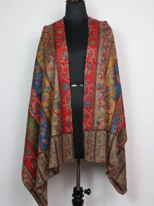 Samina stole offers soft warmth with thoughtful detailing; Samina’s edges are defined by a continuous Aari work band embroidered in golden hues, while floral corner motifs punctuate each end. Fold or drape it as needed to add a composed, Kashmiri charm to your attire.