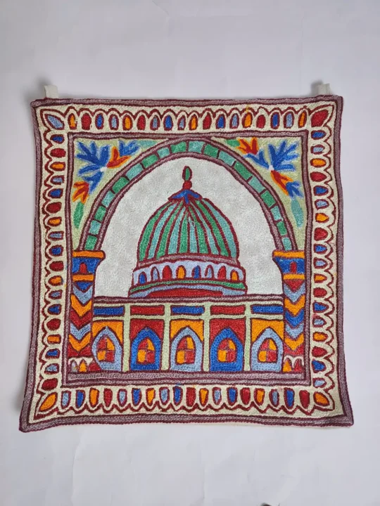 The holy Masjid of Madina is delicately embroidered using hand chain stitch on rich black dusoot cotton. The intricate detailing highlights its domes and structure with care and respect. The dark background deepens the elegance of the design, giving this wall hanging a peaceful and spiritually uplifting presence.